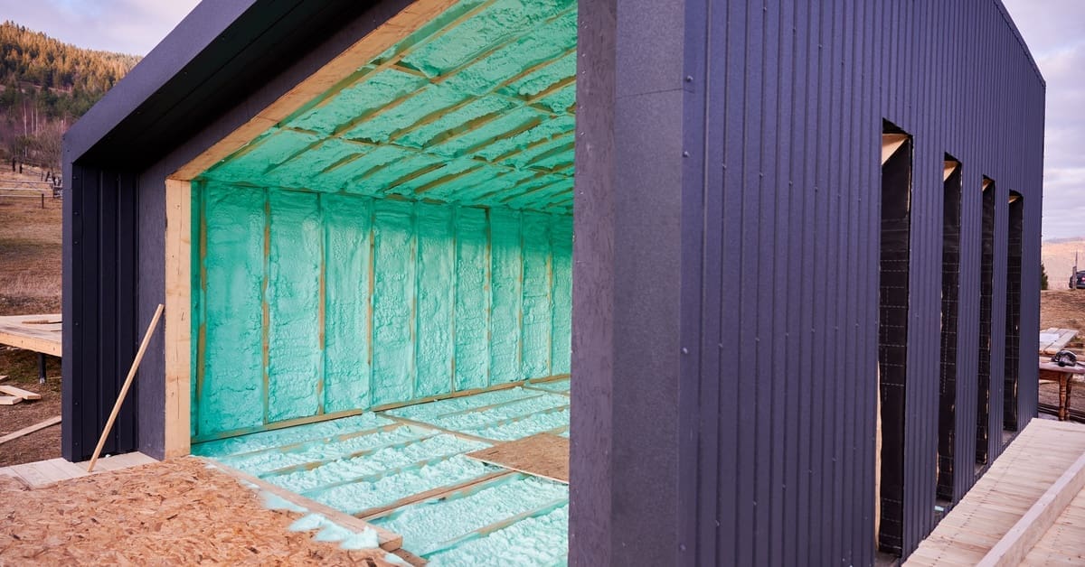 Wood-framed Scandinavian-style house exterior with polyurethane foam insulation applied between structural framing.